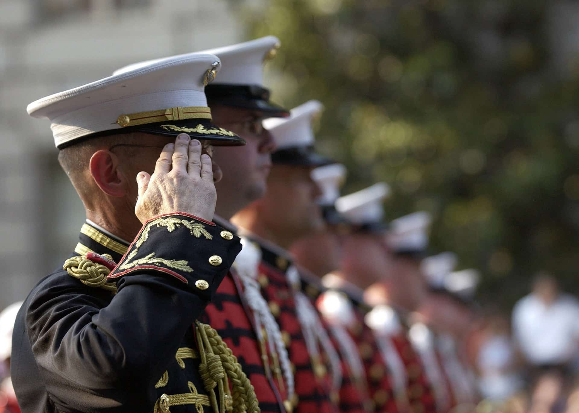 military officer in dress uniform saluting during a formal event