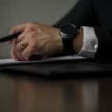 closeup of a legal persons hands holding a pen over a piece of paper